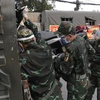 Lực lượng quân đội hỗ trợ vận chuyển xe máy cho người dân lên xe ôtô chở về quê. (Ảnh: TTXVN phát)