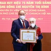 Chủ tịch nước Nguyễn Xuân Phúc trao tặng huy hiệu 75 năm tuổi Đảng cho bà Nguyễn Thị Bình, nguyên Phó Chủ tịch nước CHXHCN Việt Nam. (Ảnh: Thống Nhất/TTXVN)