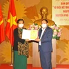 Nguyên Phó Chủ tịch thường trực Quốc hội Tòng Thị Phóng tiếp nhận Giấy chứng nhận đăng ký bản quyền tác giả. (Ảnh: Minh Đức/TTXVN)