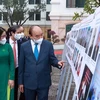 Chủ tịch nước Nguyễn Xuân Phúc xem trưng bày ảnh do Thông tấn xã Việt Nam và Học viện Nông nghiệp Việt Nam phối hợp tổ chức. (Ảnh: Thống Nhất/TTXVN)