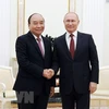 Tổng thống Nga Vladimir Putin đón Chủ tịch nước Nguyễn Xuân Phúc. (Ảnh: TTXVN)