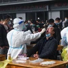 Nhân viên y tế lấy mẫu xét nghiệm COVID-19 tại khu chợ ở Hàng Châu, tỉnh Chiết Giang, Trung Quốc ngày 10/12/2021. (Ảnh: THX/TTXVN)