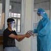 Cán bộ Trạm Y tế xã Bình Thành, huyện Thanh Bình, tỉnh Đồng Tháp đến kiểm tra sức khỏe và hướng dẫn sử dụng thuốc hỗ trợ điều trị COVID-19 cho đối tượng F0 đang điều trị tại nhà. (Ảnh: Nhựt An/TTXVN)