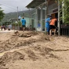 Bùn đất dày trên 30cm tràn xuống đường bê tông thôn Chánh Thắng. (Ảnh: Tường Quân/TTXVN)