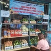 Người dân mang rau, hàng hóa đến để góp vào gian hàng 0 đồng hỗ trợ người ở điểm cách ly phường Tân Quý, quận Tân Phú. (Ảnh: TTXVN phát)