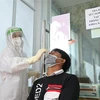 Nhân viên y tế lấy mẫu xét nghiệm COVID-19 cho người dân tại bệnh viện Đa khoa khu vực Nghĩa Lộ (Yên Bái). (Ảnh: Minh Quyết/TTXVN)