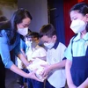 Đại diện "Quỹ xã hội từ thiện Tấm lòng vàng" trao quà và học bổng cho các em học sinh là con em công nhân Công ty TNHH May thêu giày An Phước có hoàn cảnh khó khăn. (Ảnh: Thanh Vũ/TTXVN)
