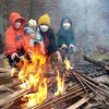 Người dân huyện Yên Lạc (Vĩnh Phúc) đốt lửa sưởi ấm trong tiết trời lạnh giá. (Ảnh: Hoàng Hùng/TTXVN)