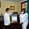 Đại sứ Việt Nam tại Cuba Lê Thanh Tùng trao quà tượng trưng cho Hiệu trưởng trường tiểu học “Bác Hồ” Milagros Negret Calderín. (Ảnh: Vũ Lê Hà/TTXVN)