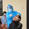 Nhân viên y tế Trạm y tế lưu động số 1 xã Tân Triều, huyện Thanh Trì lấy mẫu xét nghiệm sàng lọc cho người dân trước khi hết cách ly, điều trị. (Ảnh: Hoàng Hiếu/TTXVN)