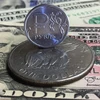 Đồng xu ruble của Nga (phía trên) và đồng USD tại Moskva. (Ảnh: AFP/TTXVN)