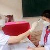 Khám sàng lọc trước khi tiêm vaccine phòng COVID-19 cho trẻ 11 đến dưới 12 tuổi tại Trường Trung học cơ sở Yên Định, huyện Hải Hậu, tỉnh Nam Định. (Ảnh: Văn Đạt/TTXVN)