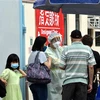 Nhân viên y tế hướng dẫn người dân tại một điểm xét nghiệm COVID-19 ở Hong Kong, Trung Quốc. (Ảnh: THX/TTXVN)