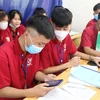 Hướng dẫn đăng ký dự thi cho học sinh tại trường THPT Nguyễn Trường Tộ, huyện Hưng Nguyên, Nghệ An. (Ảnh: Bích Huệ/TTXVN)