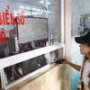 Người dân đến đăng ký và thực hiện bấm nút lấy biển số xe ôtô tại Công an huyện Phong Điền, thành phố Cần Thơ. (Ảnh: TTXVN phát)
