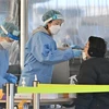Nhân viên y tế lấy mẫu xét nghiệm COVID-19 cho người dân ở Seoul, Hàn Quốc. (Ảnh: AFP/TTXVN)