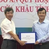 Đại diện của Vụ Quy hoạch kiến trúc, Bộ Xây dựng trao Hồ sơ quy hoạch chung xây dựng Khu kinh tế cửa khẩu tỉnh Cao Bằng cho đại diện lãnh đạo tỉnh Cao Bằng. (Ảnh: Quốc Đạt/TTXVN)