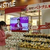 Một khách hàng người Nhật Bản chọn mua dừa Việt Nam ở siêu thị AEON. (Ảnh: Đào Thanh Tùng/TTXVN)