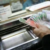 Kiểm tiền ringgit của Malaysia tại một quầy giao dịch tiền tệ ở Kuala Lumpur. (Ảnh: AFP/ TTXVN)