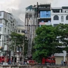 Cảnh sát phòng cháy chữa cháy và cứu nạn, cứu hộ, Công an thành phố Hà Nội đã dùng xe thang đưa lực lượng chữa cháy lên khu vực tầng thượng của ngôi nhà. (Ảnh: TTXVN phát)