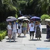 Người dân che ô tránh nắng trên đường phố tại tỉnh Phúc Kiến, Trung Quốc, ngày 24/7/2022. (Ảnh: AFP/TTXVN)