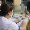 Nhân viên y tế quận Đống Đa (Hà Nội) tiêm vaccine cho học sinh trường THCS Bế Văn Đàn. (Ảnh: Minh Quyết/TTXVN)