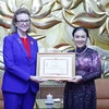 Chủ tịch Liên hiệp các tổ chức hữu nghị Việt Nam Nguyễn Phương Nga trao Kỷ niệm chương cho Trưởng đại diện Thường trú Chương trình phát triển Liên hợp quốc (UNDP) tại Việt Nam Caitlin Wiesen. (Ảnh: An Đăng/TTXVN)
