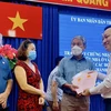Chủ tịch Ủy ban Nhân dân thành phố Thủ Đức Hoàng Tùng (bên phải) trao Giấy chứng nhận quyền sử dụng đất, nhà ở cho người dân. (Ảnh: Hồng Giang/TTXVN)