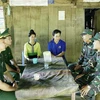 Bộ đội Biên phòng Việt Nam phối hợp với lực lượng bảo vệ biên giới của Lào tuyên truyền đến người dân nước bạn sinh sống tại khu vực biên giới. (Ảnh: Xuân Tư/TTXVN)