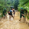 Cán bộ chiến sĩ Đồn biên phòng Phúc Sơn giúp người dân xã Phúc Sơn, huyện Anh Sơn khắc phụ hậu quả mưa lũ. (Ảnh: TTXVN phát)