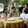 Chủ tịch Ủy ban MTTQ Việt Nam thành phố Đà Nẵng Ngô Xuân Thắng (giữa) thăm hỏi, hỗ trợ 10 triệu đồng/hộ cho các hộ gia đình có người thân tử vong trong mưa lũ. (Ảnh: Quốc Dũng/TTXVN)