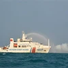 Tàu CSB 8004 thực hành phun nước dập cháy tàu bị nạn trong luyện tập phối hợp tìm kiếm cứu nạn. (Ảnh: TTXVN phát)