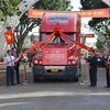 Các đại biểu thực hiện nghi thức kéo dải lụa đỏ cho xe chạy xuất khẩu container macca Krông Năng đầu tiên. (Ảnh: Hoài Thu/TTXVN)