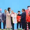 Thủ tướng Phạm Minh Chính tặng Thủ tướng New Zealand Jacinda Ardern chiếc áo thi đấu có chữ ký của đội tuyển bóng đá nữ Việt Nam. (Ảnh: Dương Giang/TTXVN)