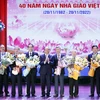 Chủ tịch nước Nguyễn Xuân Phúc chúc mừng các nhà giáo nhân dân. (Ảnh: Thống Nhất/TTXVN)
