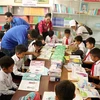 Học sinh trường tiểu học Nơ Trang Lơng đọc sách từ chương trình Tủ sách Đinh Hữu Dư trao tặng. (Ảnh: Hoài Thu/TTXVN)