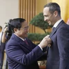 Thủ tướng Phạm Minh Chính trao Huy chương Hữu nghị của Chủ tịch nước cho ông John Paul Pullicino Said Anthony, nguyên Tổng giám đốc Công ty TNHH Pfizer Việt Nam. (Ảnh: Dương Giang/TTXVN)