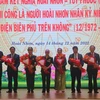 Tặng hoa cho người thân của 4 phi công Anh hùng lực lượng vũ trang nhân dân. (Ảnh: Sỹ Thắng/TTXVN)