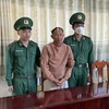 Đối tượng Nguyễn Văn Phán (giữa) bị bắt giữ trong trường hợp khẩn cấp. (Ảnh: TTXVN phát)