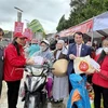 Phó chủ tịch UBND tỉnh Lâm Đồng Phạm S tặng quà cho người có hoàn cảnh khó khăn trong Hội chợ Tết nhân ái Xuân Quý Mão 2023. (Ảnh: Nguyễn Dũng/TTXVN)