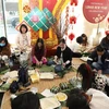 Người Việt tại Anh tham gia cuộc thi gói bánh chưng tại Lễ hội Tết Nguyên đán Nhâm Dần. (Ảnh: Đình Thư/TTXVN)