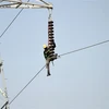 Kỹ thuật viên sửa chữa đường dây điện cao thế tại Karachi, Pakistan. (Ảnh: AFP/ TTXVN)