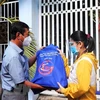 Đại diện Hội đồng nhân dân Tp. Hồ Chí Minh trao quà tặng và động viên công nhân ở trọ, người lao động có hoàn cảnh khó khăn ở Quận 8 trong đại dịch COVID-19. (Ảnh: Thanh Vũ/TTXVN)
