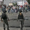 Người Palestine và các lực lượng Israel trong cuộc đụng độ tại Nablus ngày 15/5/2022. (Ảnh: AFP/ TTXVN)