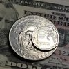 Đồng xu ruble của Nga (trên) và đồng đôla Mỹ. (Ảnh: AFP/TTXVN)