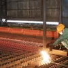 Công nhân Nhà máy cán thép Thái Trung - Công ty cổ phẩn Gang thép Thái Nguyên lấy mẫu thép thành phẩm sau khi cán. (Ảnh: Hoàng Nguyên/TTXVN)