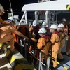 Các cán bộ, nhân viên của Trung tâm Phối hợp tìm kiếm, cứu nạn hàng hải Việt Nam đưa nạn nhân lên bờ đi cấp cứu tại thành phố Nha Trang. (Ảnh: TTXVN phát)