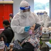 Nhân viên y tế lấy mẫu xét nghiệm COVID-19 cho người dân tại Kuala Lumpur, Malaysia. (Ảnh: AFP/TTXVN)