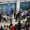 Du khách Trung Quốc được hướng dẫn tới khu vực kiểm dịch COVID-19 tại sân bay quốc tế Incheon, phía Tây Seoul (Hàn Quốc) ngày 2/1/2023. (Ảnh: AFP/TTXVN)