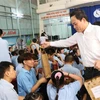 Phó Thủ tướng Trần Lưu Quang tặng quà cho các em học sinh ở Trung tâm Phục hồi chức năng - Giáo dục trẻ em khuyết tật tỉnh Khánh Hòa. (Ảnh: Phan Sáu/TTXVN)
